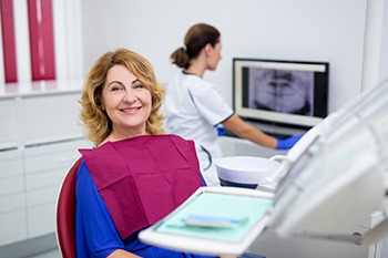 An older woman smiling at her implant consultation.
