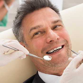 Man with healthy smile receiving dental exam