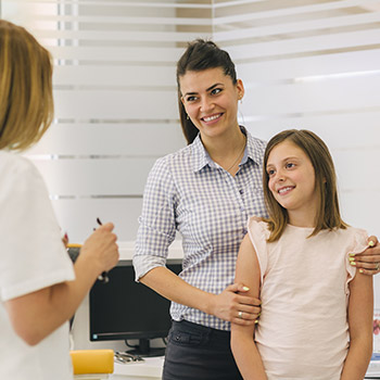 Smiling mother and daughter in dental office