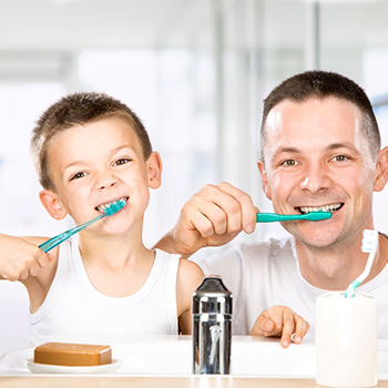 father and son brushing teeth