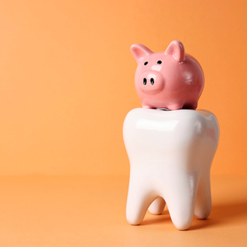 Piggy bank on large model tooth with orange background