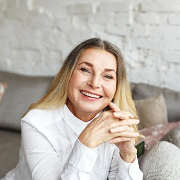 Senior woman sitting on couch and smiling