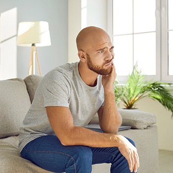 Bearded man with tooth pain that needs an emergency dentist in Portage, IN