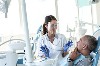 Dentist explaining how dental implants work in Portage to patient.