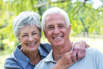 An older couple smiling outside.