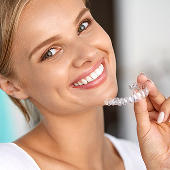 Woman holding Invisalign tray