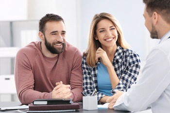 A couple talking with a dentist during a consultation