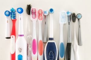 a lineup of different used toothbrushes