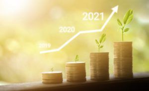 four stacks of growing coins with plants on top of them signifying a growth in savings