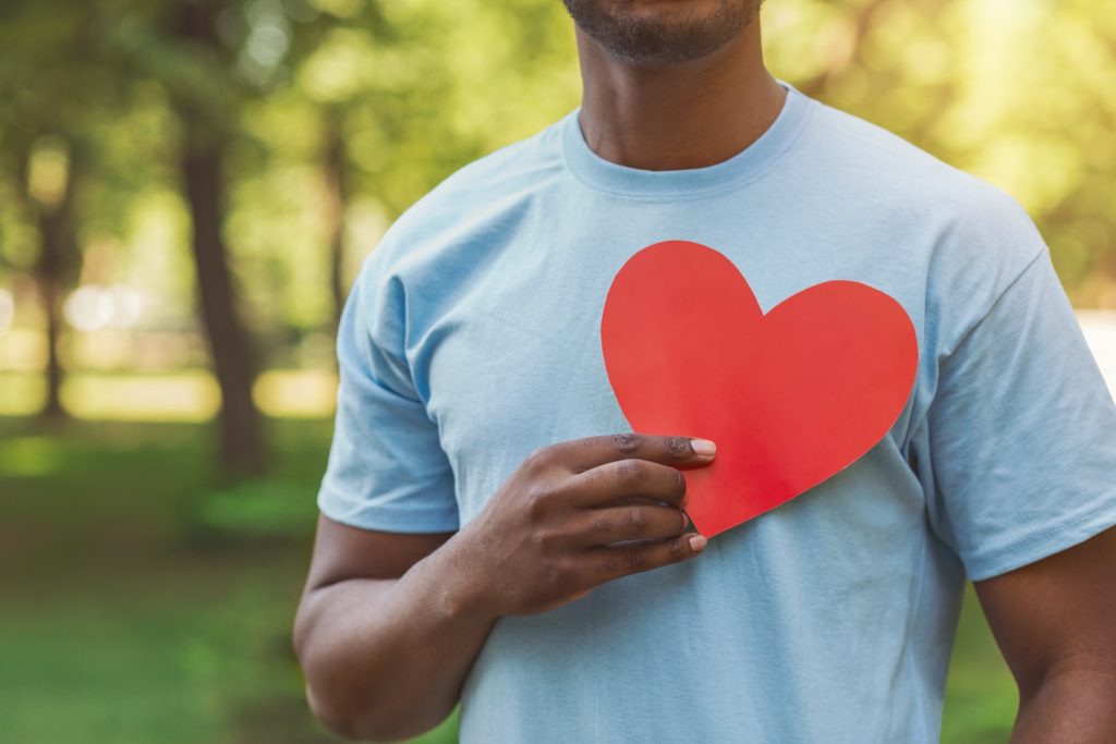 Man holding cut out heart over his chest