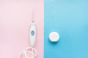 a Waterpik next to traditional dental floss